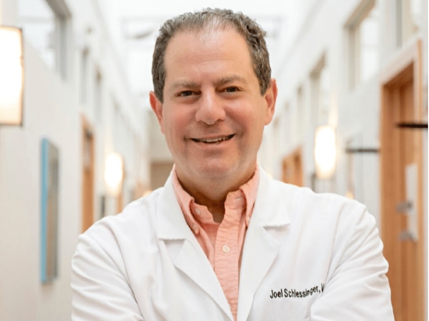 Profile of Dr. Joel Schlessinger in lab coat standing in a hallway inside Schlessinger MD office