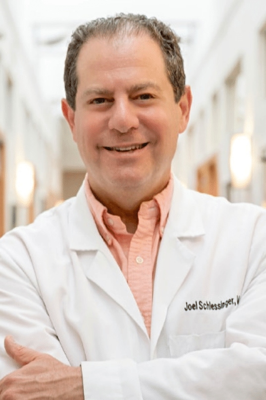 Profile of Dr. Joel Schlessinger in lab coat standing in a hallway inside Schlessinger MD office